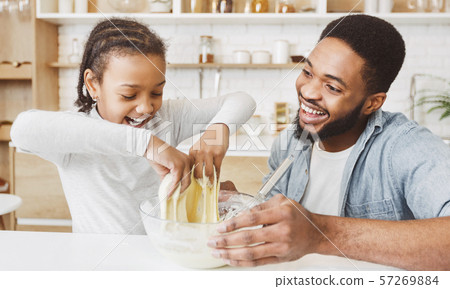 Excited little black girl playing with pastry dough 57269884