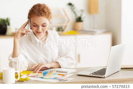 Dressmaker speaking on cellphone and looking at palette Dressmaker speaking on cellphone and looking at palette 57270815