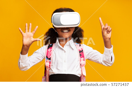 Black Schoolgirl Using VR Headset Experiencing Virtual Reality In Studio 57271437