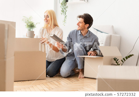 Young Spouses Unpacking Moving Boxes In New House After Relocation Young Spouses Unpacking Moving Boxes In New House After Relocation 57272332