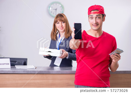 Young male courier delivering pizza to hotel's reception Young male courier delivering pizza to hotel's reception 57273026