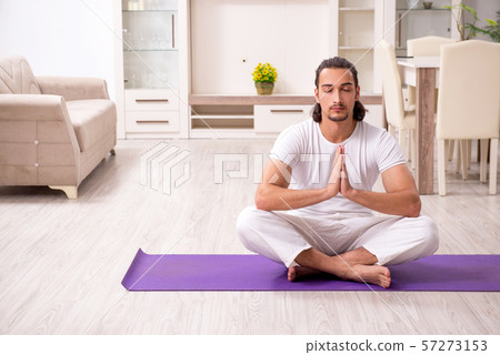 Young man doing physical exercises at home 57273153