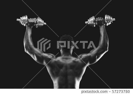 Back view of afro sportsman pushing dumbbells up 57273780