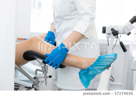 The gynecologist helps the patient to sit in the The gynecologist helps the patient to sit in the 57274039