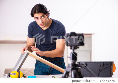 Young male repairman recording video for his blog Young male repairman recording video for his blog 57274270