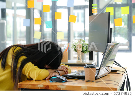 Asian female programmer wearing a yellow shirt and Asian female programmer wearing a yellow shirt and 57274955