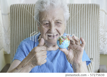 senior woman holding a globe 57275630