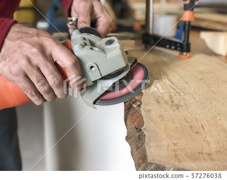 closeup hands of a carpenter working with emery 57276038