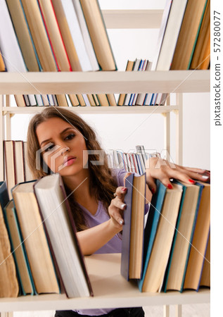 Young female student preparing for exams at library 57280077