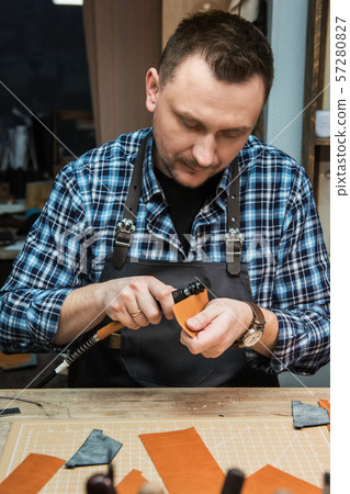 Concept of handmade craft production of leather goods. Concept of handmade craft production of leather goods. 57280827