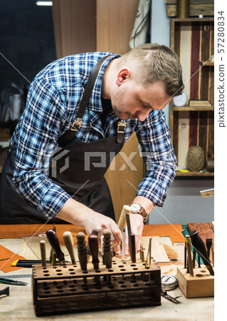 Concept of handmade craft production of leather goods. Concept of handmade craft production of leather goods. 57280834