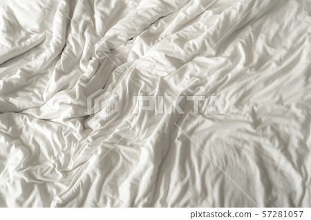The texture of the white bedsheet is wrinkled. 57281057