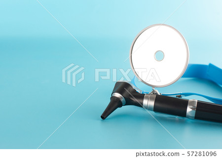 Otoscope with reflector mirror on blue background 57281096