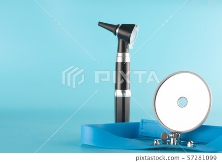 Otoscope with reflector mirror on blue background 57281099