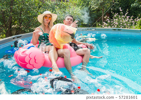 Problem of trash, plastic recycling, pollution and environmental concept - silly man and woman swim Problem of trash, plastic recycling, pollution and environmental concept - silly man and woman swim 57281601
