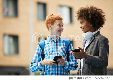 Two friends using phones Two friends using phones 57282832