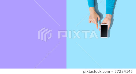 Person using a white smartphone Person using a white smartphone 57284145