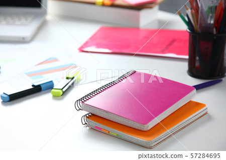 Closeup of white desktop with notepads, pen and other items. Selective focus. 57284695