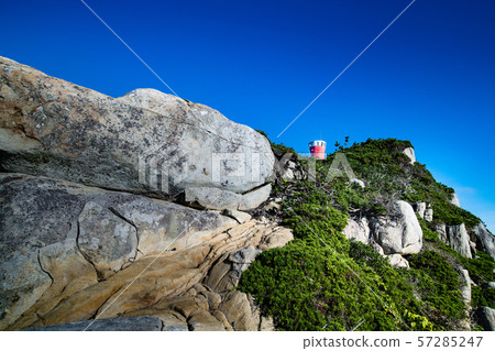 Red lighthouse and cliffs ahead of the morning cape 57285247