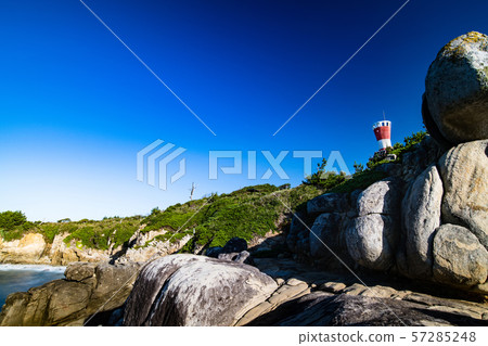 Red lighthouse and cliffs ahead of the morning cape 57285248