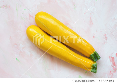 Fresh yellow squash on a pink background Fresh yellow squash on a pink background 57286363