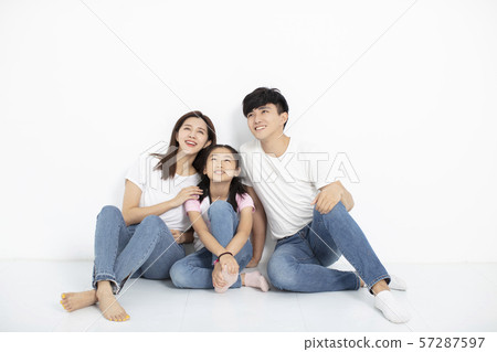Happy Young family Sitting On Floor Looking Up 57287597