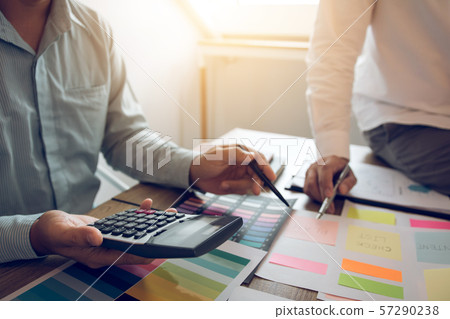 Managers using calculator to analyze sales cost 57290238