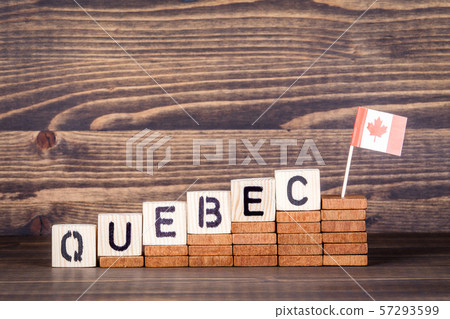 Quebec Canada. Politics, economic and immigration concept. Wooden letters and flag on the office desk Quebec Canada. Politics, economic and immigration concept. Wooden letters and flag on the office desk 57293599