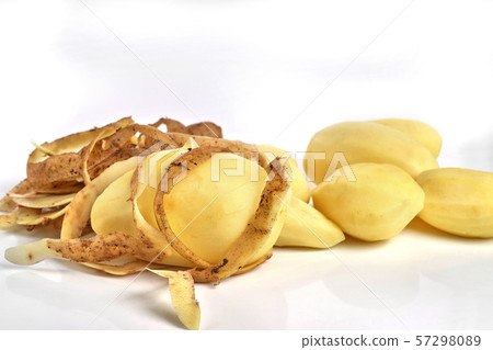 Peeled potatoes and potato peel on a white 57298089