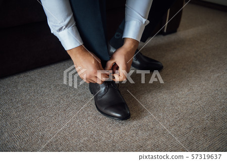 Business man tying shoe laces on the floor. Close-up 57319637