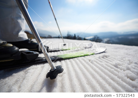 Skier legs in white snow, beautiful winter mountain landscape and blue sky copy space background. Skier legs in white snow, beautiful winter mountain landscape and blue sky copy space background. 57322543