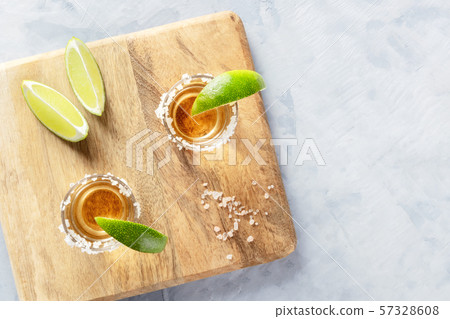 Golden tequila shots with lime slices and salt, shot from above with a place for text 57328608