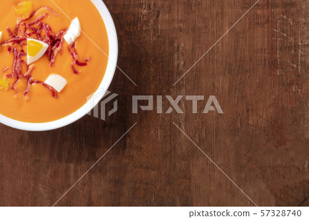 Salmorejo, Spanish cold tomato soup, close-up shot from the top on a dark rustic wooden background Salmorejo, Spanish cold tomato soup, close-up shot from the top on a dark rustic wooden background 57328740