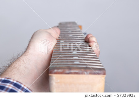 defect fretboard of electric guitar in the hands of a master 57329922