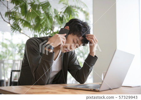 拿著他的頭的一個人，當談話在智能手機時 57329943