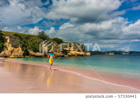 Woman enjoying happiness and freedom while walking on a tropical beach 57330441