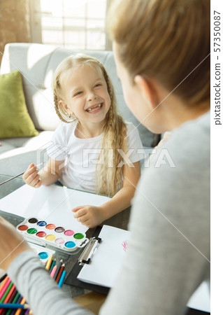 Teacher and little girl, or mom and daughter. Homeschooling concept Teacher and little girl, or mom and daughter. Homeschooling concept 57350087