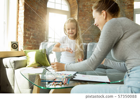 Teacher and little girl, or mom and daughter. Homeschooling concept Teacher and little girl, or mom and daughter. Homeschooling concept 57350088