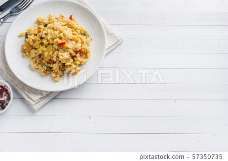 Pilaf with vegetables and chicken in a gray plate on a light background. Copy space Pilaf with vegetables and chicken in a gray plate on a light background. Copy space 57350735