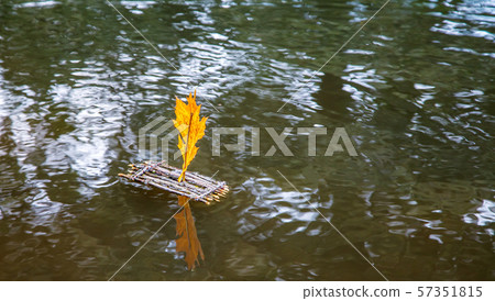 toy raft with a sail floating on the lake 57351815