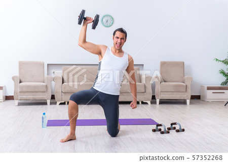 Young man training and exercising at home Young man training and exercising at home 57352268