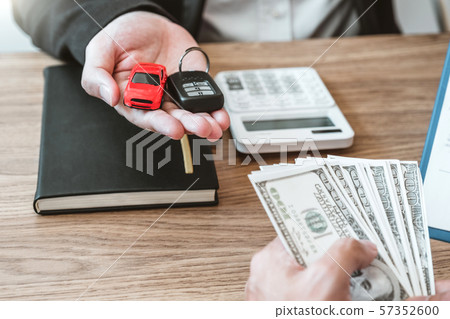 Sale agent giving Car key to customer and sign Sale agent giving Car key to customer and sign 57352600