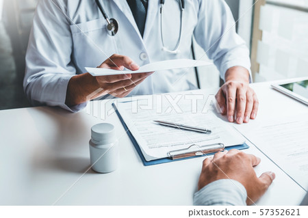 Doctor or physician writing diagnosis and giving a 57352621