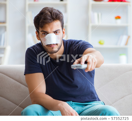 Young man recovering healing at home after plastic surgery nose 57352725