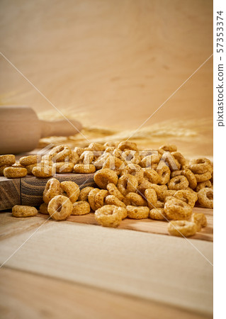 crunchy breakfast on a wooden table with ears of rye and rolling pin 57353374