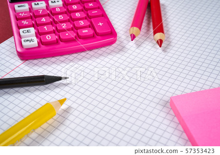 open notebook with checkered pages and calculator and pencil 57353423