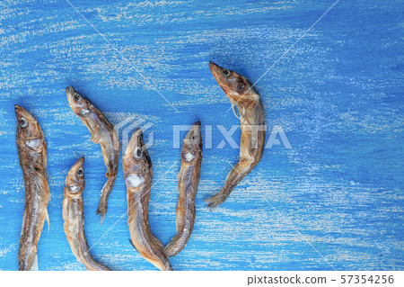 dried smelt fish six pieces on a wooden painted background similar to the sea 57354256