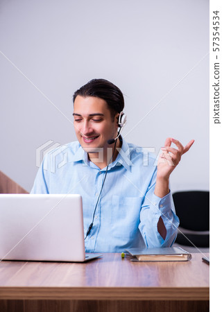 Call center operator working at his desk Call center operator working at his desk 57354534