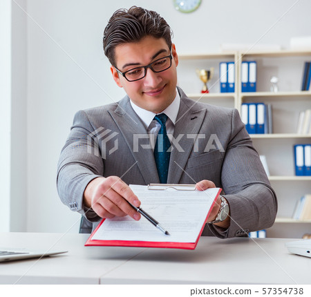 Businessman signing business documents in office Businessman signing business documents in office 57354738