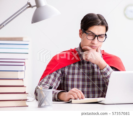Super hero student with a laptop studying preparing for exams 57357081